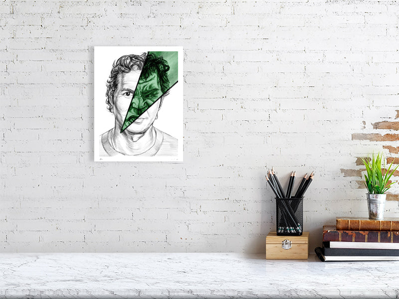 A medium size unframed pencil drawing hanging on a white brick wall. The artwork is of Bruce Banner, showing a split image with most of the face depicting a calm expression and a cut through green section showing an angry expression resembling the Hulk.