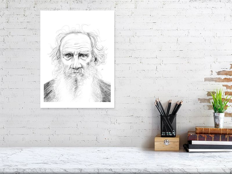 A large unframed pencil drawing of Leo Tolstoy with intricate details, hanging on a white brick wall over a desk.