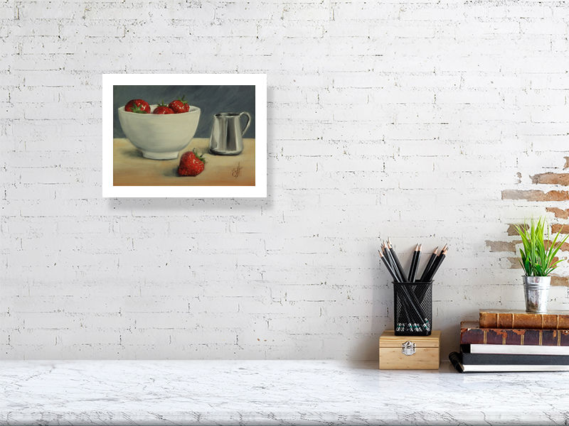 A small giclee print featuring a bowl of strawberries and a silver cream jug on a wooden surface, signed by Sophie Hall and hanging over a white marble desk.