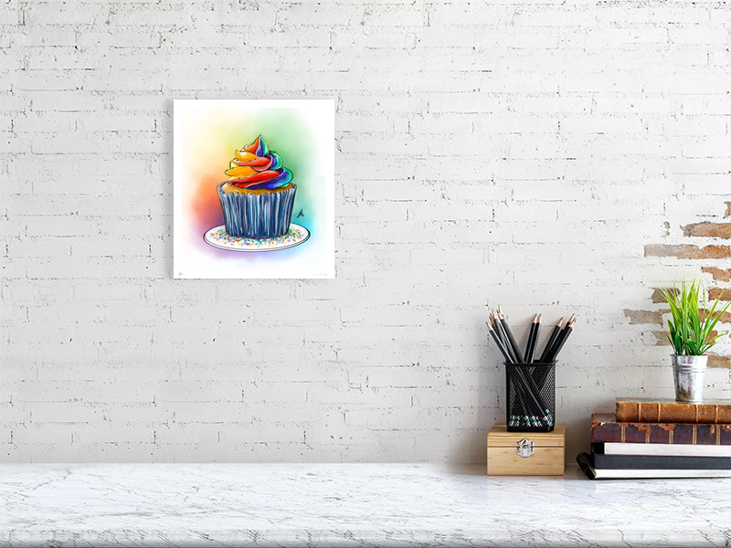 A medium unframed print of Frost, by Sophie Hall: an artistic ink drawing of a cupcake topped with multi-colored frosting, depicted with vibrant pastel colours. The print hangs on a white brick wall.