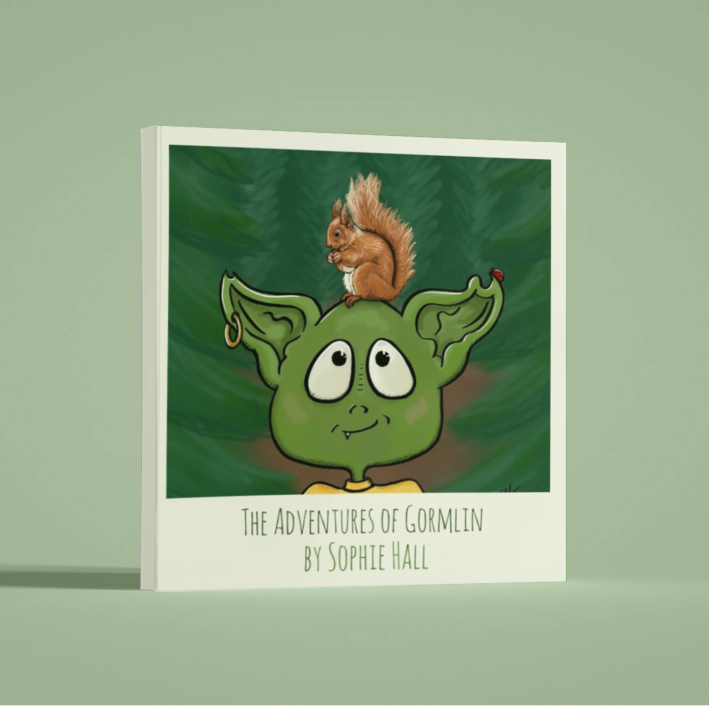 Mock up image of picture book "The Adventures of Gormlin" by Sophie Hall, featuring a green goblin with a red squirrel on it's head