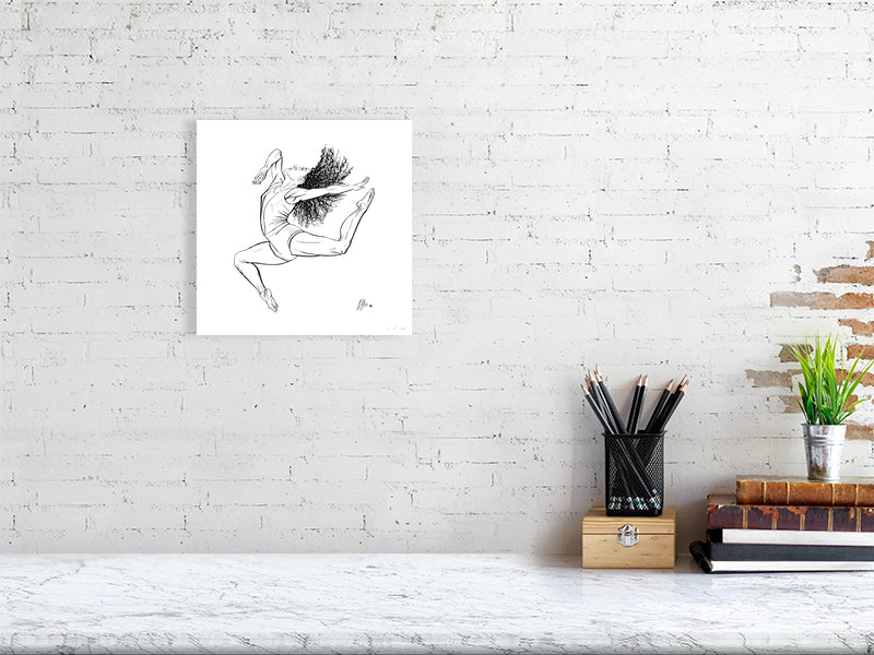 A small unframed ink drawing of a ballet dancer in mid-leap, signed by Sophie Hall and hanging on a white brick wall over a marble desk.