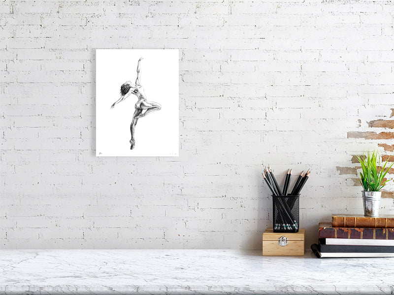 Small unframed pencil drawing of a ballet dancer mid Pique pose, with arms outstretched, signed in the corner by Sophie Hall and hanging on a white wall over a desk.