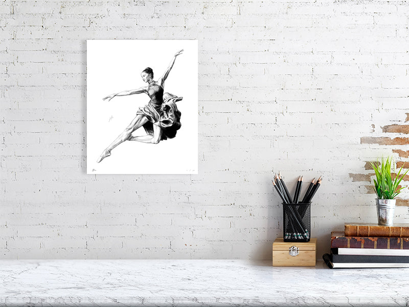 A medium size unframed pencil drawing of a ballet dancer in mid-jump, hanging on a white brick wall.