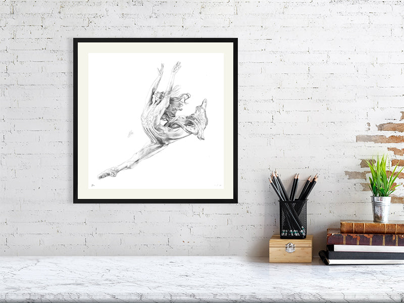 Large framed pencil drawing of a ballet dancer in a dynamic leap pose, inspired by Stravinsky's Firebird ballet. Hanging on a white brick wall above a marble desk.