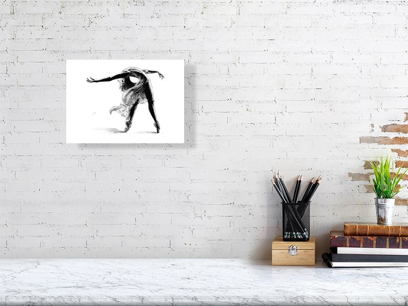 A4 size unframed print of a pencil drawing of a ballet dancer mid pose, by Sophie Hall. Print hangs on a white brick wall.