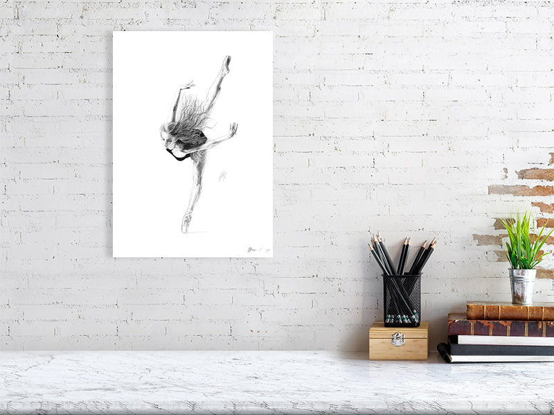 A large unframed pencil drawing on a white background of a ballet dancer en pointe in mid-bend, with limbs outstretched and loose hair. Signed with Sophie Hall's monogram and hanging on a white brick wall over a desk.