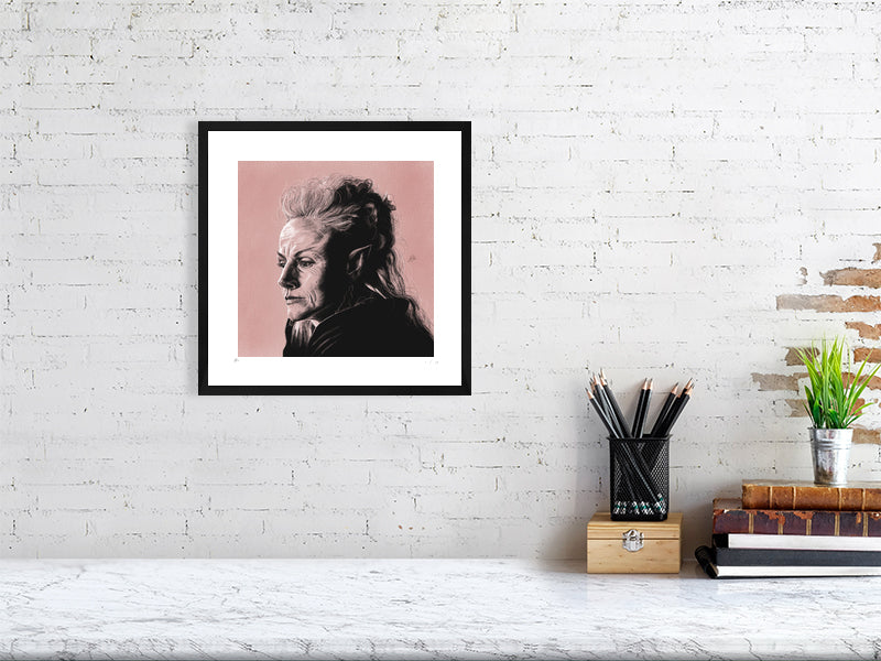 A framed pencil and chalk portrait of Maxine Peake as Titania, on a pink pastel textured background, in a black frame. Hanging on a white brick wall over a desk.