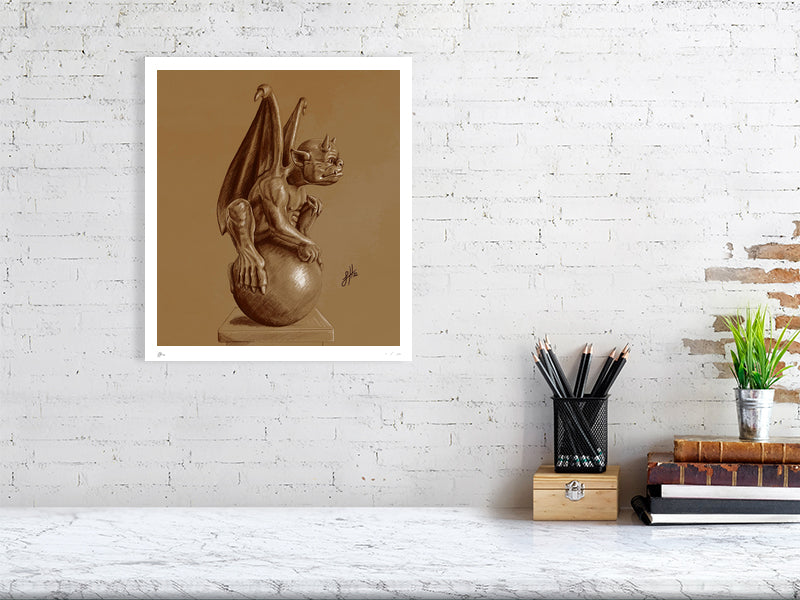 A large unframed pencil drawing of a winged gargoyle creature sitting on a ball, rendered in brown pencil and chalk on a textured sienna paper and hanging on a white brick wall over a desk.