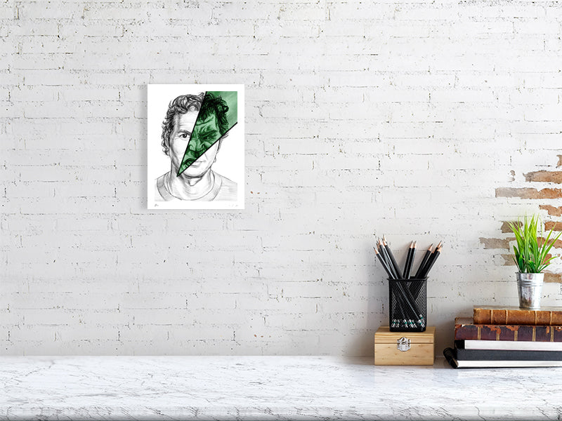 A small unframed pencil drawing hanging on a white brick wall. The artwork is of Bruce Banner, showing a split image with most of the face depicting a calm expression and a cut through green section showing an angry expression resembling the Hulk. 