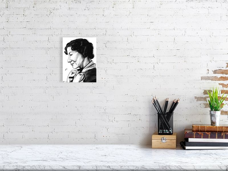 A small, unframed black and white ink drawing of a woman with her head slightly tilted, looking off to the side, hanging on a white brick wall above a desk.