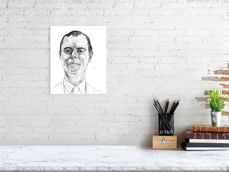 A large unframed pencil drawing portrait of Kevin Eldon as the Cleaner from the TV series Black Books. Signed in the corner and hanging on a white brick wall over a desk.