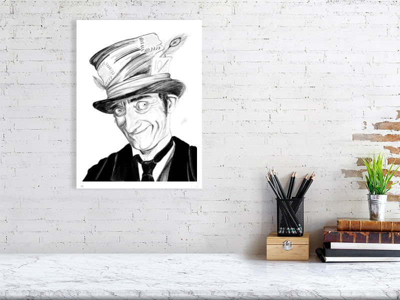 A large size unframed print of a pencil portrait drawing featuring actor Marty Feldman as the Mad Hatter. Signed by Sophie Hall and hanging on a white brick wall over a desk.