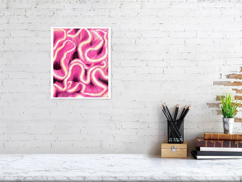 A medium unframed artwork featuring vibrant coloured pencil illustration of pink and white brain coral, hanging on a white brick wall above a desk.