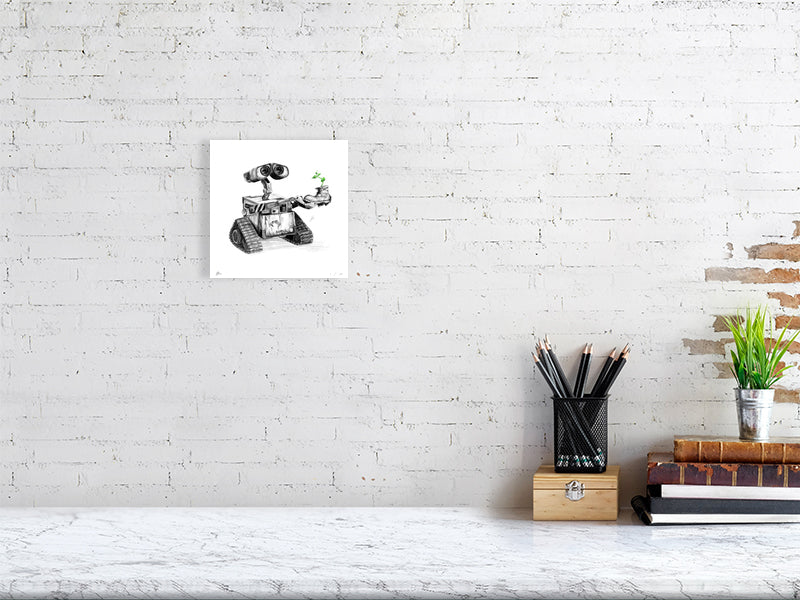A small unframed pencil drawing of the iconic character Wall-E holding a small plant growing out of a boot, hanging on a white brick wall above a desk.