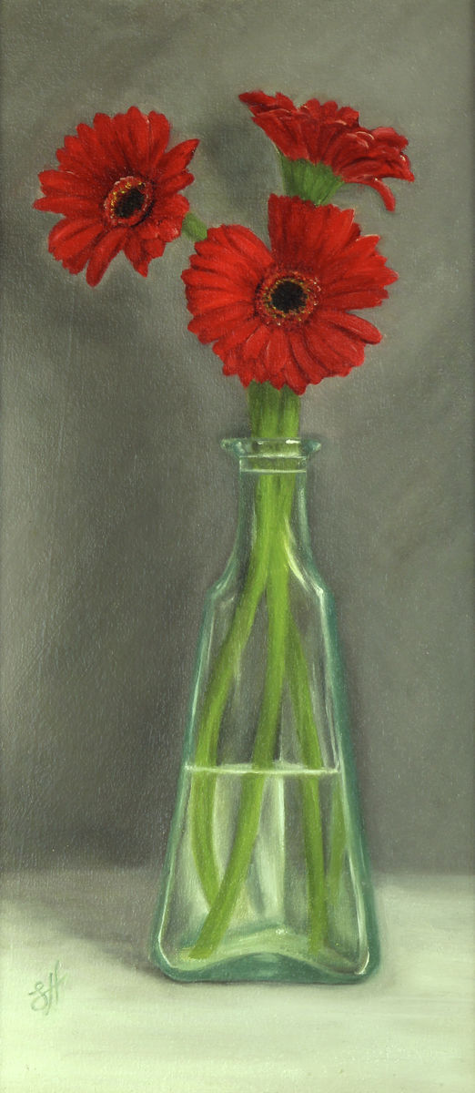 Traditional style oil painting of three bright red gerbera flowers in a clear glass bottle, with a grey background. Signed by the artist Sophie Hall.