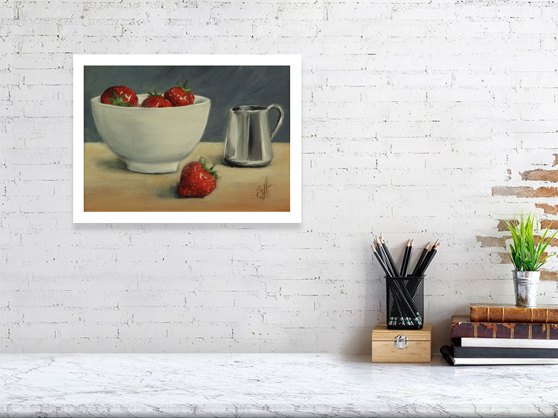 A large giclee print featuring a bowl of strawberries and a silver cream jug on a wooden surface, signed by Sophie Hall and hanging over a white marble desk.